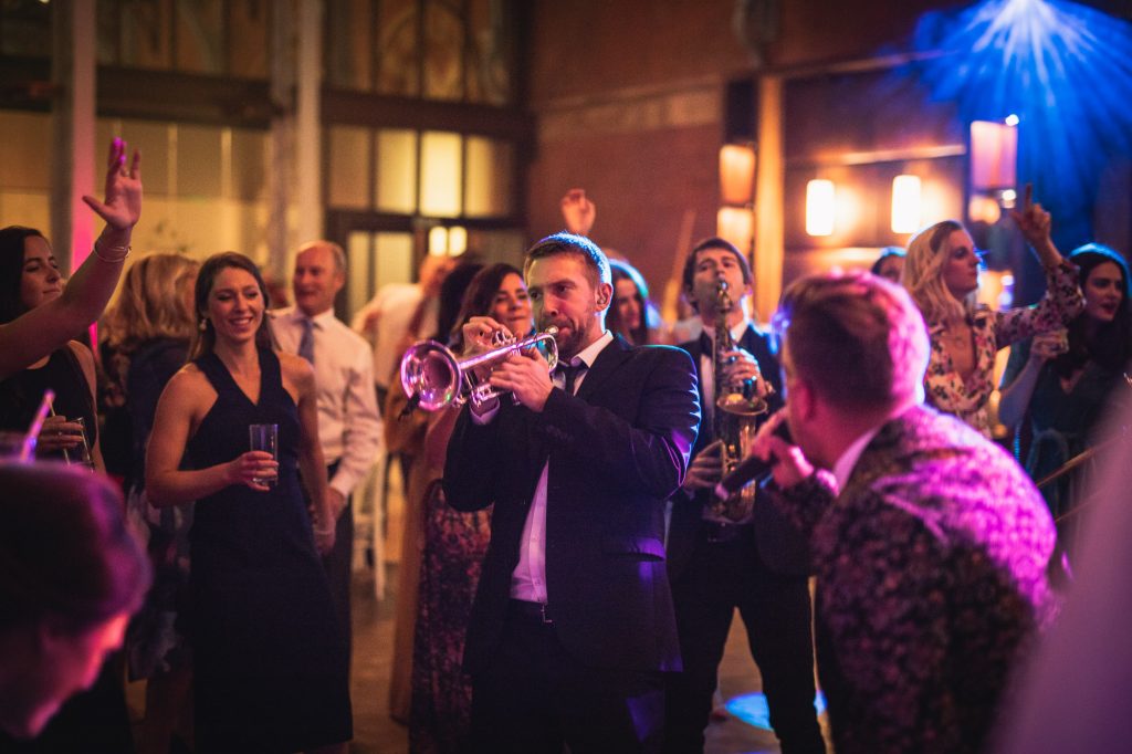 Musicians performing amongst wedding guests